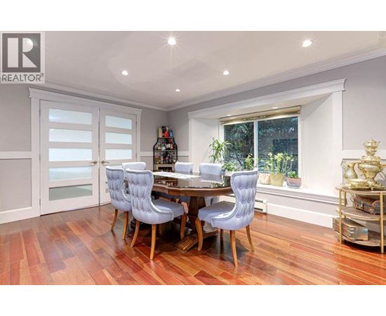 A dining room with a table and chairs.