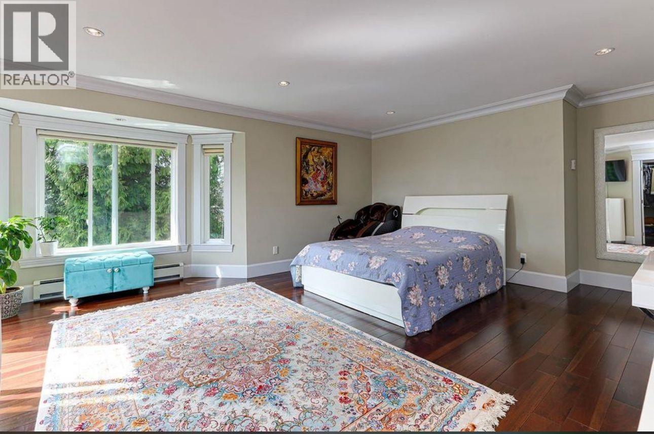 A bedroom with a large bed and a colorful rug.