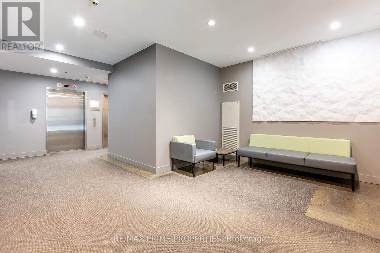 A spacious waiting area with a bench, chairs, and a carpeted floor.
