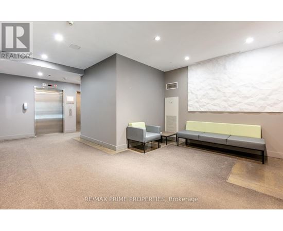 A spacious waiting area with a bench, chairs, and a carpeted floor.