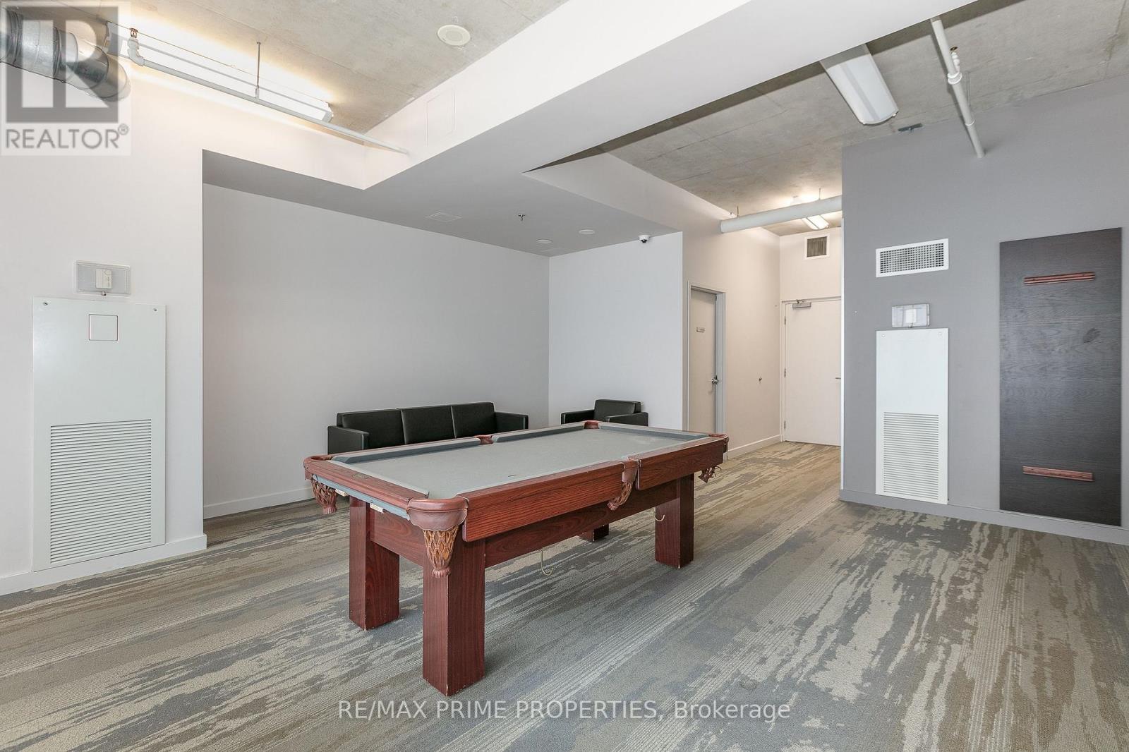 A pool table is in the middle of a room with a wood floor.