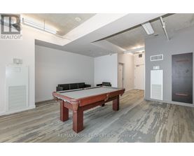 A pool table is in the middle of a room with a wood floor.