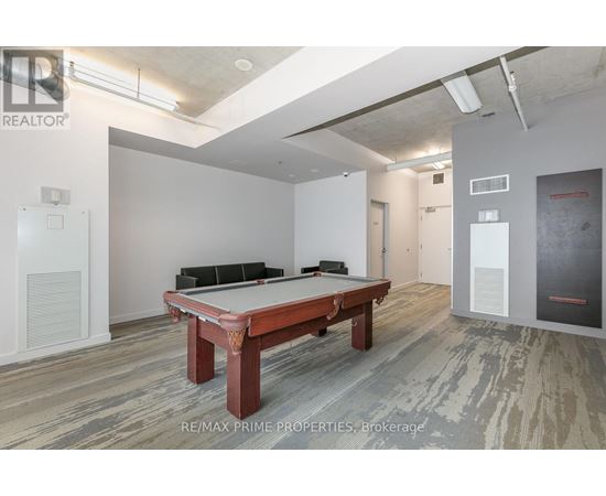 A pool table is in the middle of a room with a wood floor.