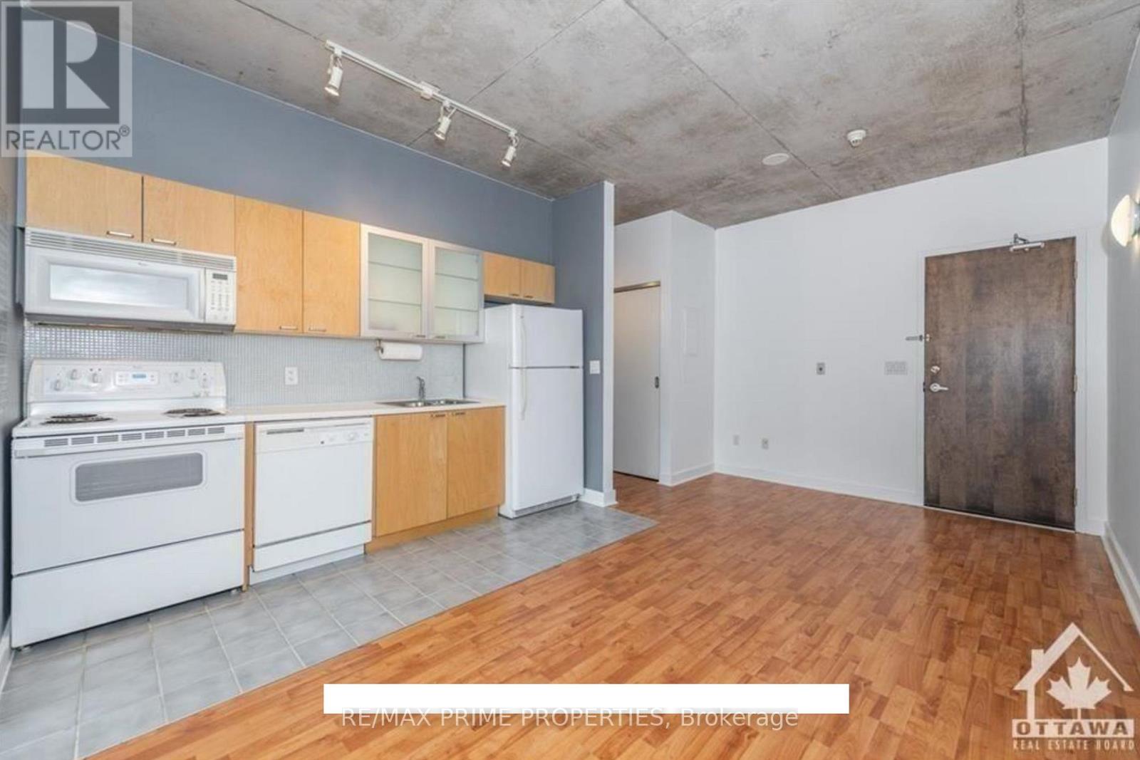 A kitchen with white appliances and wooden cabinets is on the market.