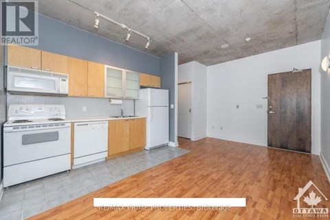A kitchen with white appliances and wooden cabinets is on the market.