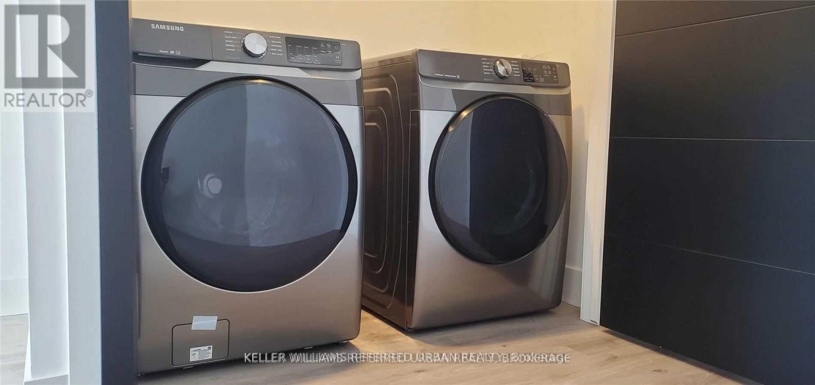 Two Keller Williams Realty washing machines are in a laundry room.