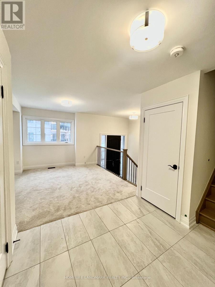 A spacious room with a carpeted floor and a staircase.