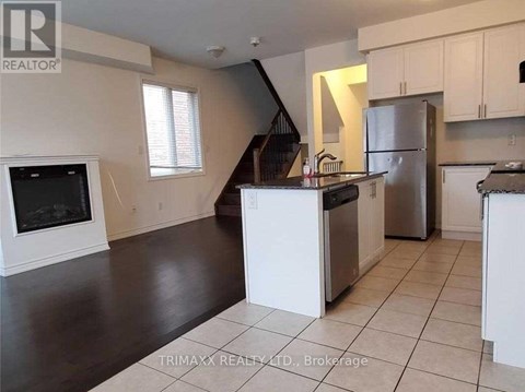 A kitchen with white cabinets and a black countertop.