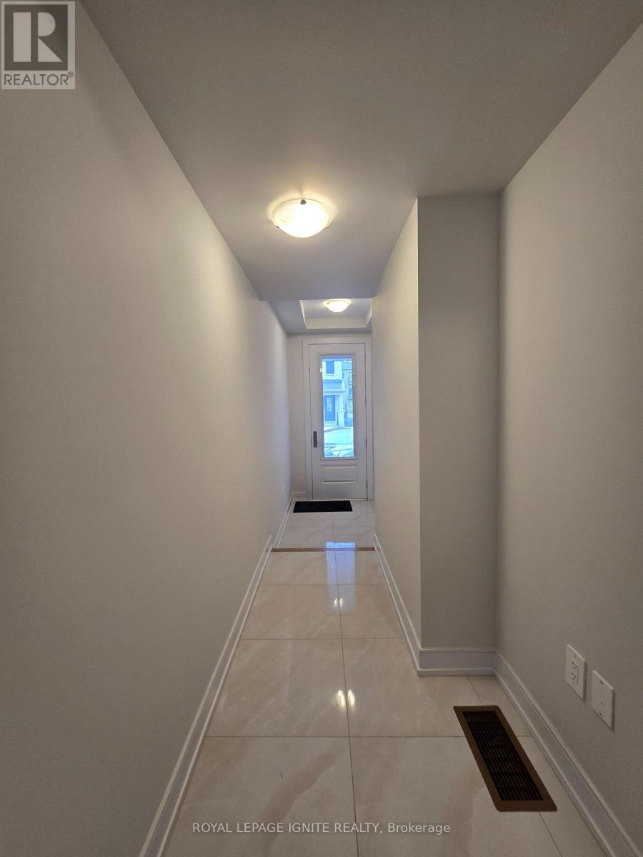 A spacious room with wooden flooring and a staircase with black railings.