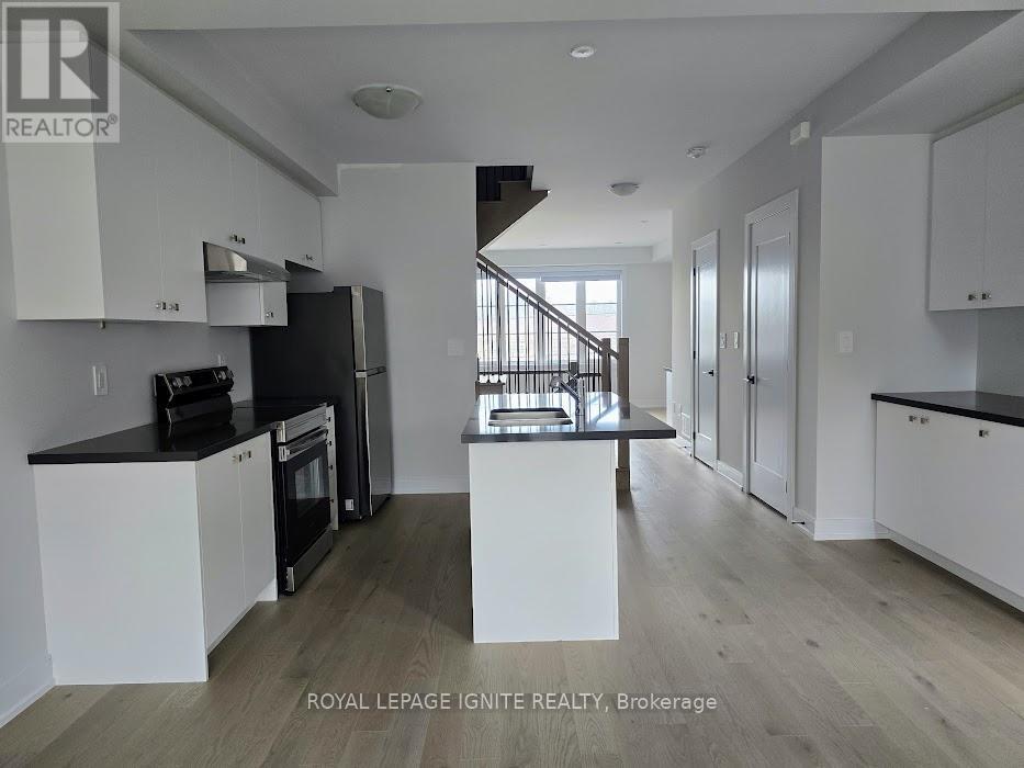 A modern kitchen with white cabinets and a black countertop.