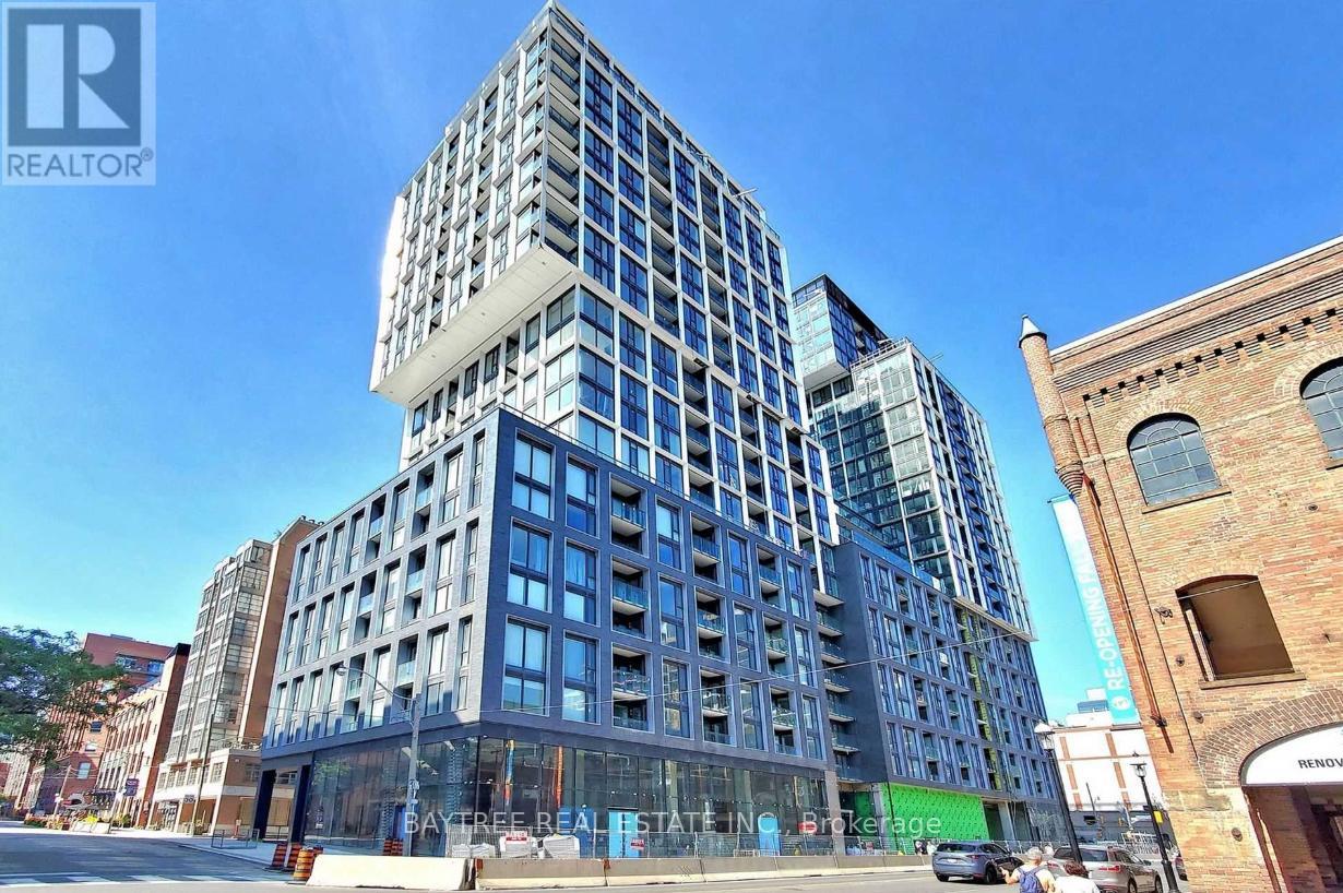 A modern multi-story building with a glass facade is under construction.