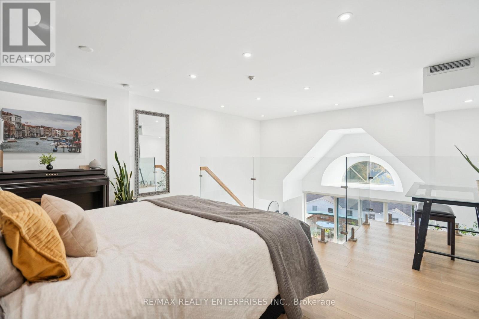 A bedroom with a large bed and a poster on the wall.