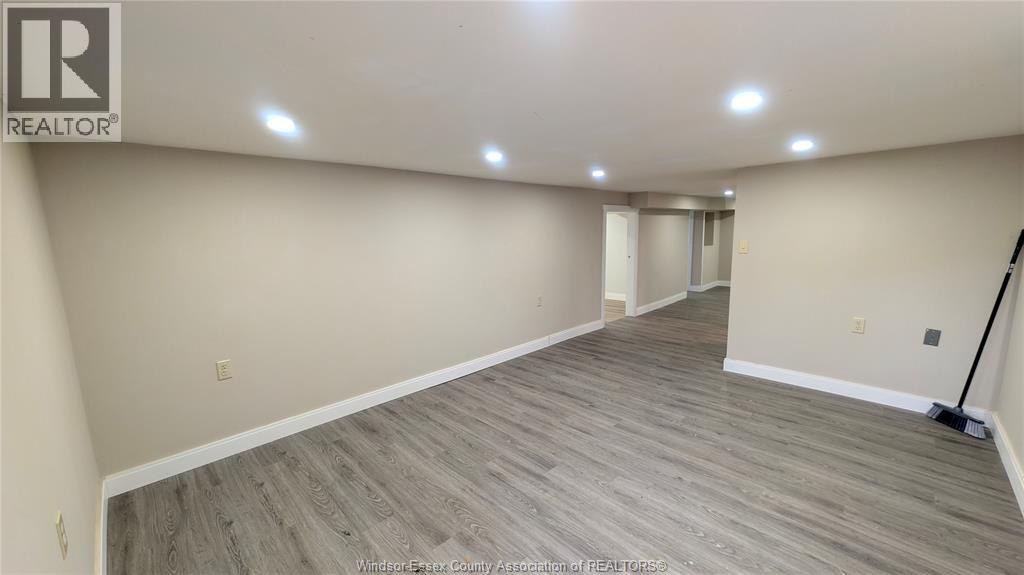 A room with wooden flooring and a REALTOR® logo on the wall.