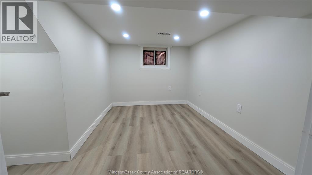A room with wooden flooring and a picture frame on the wall.