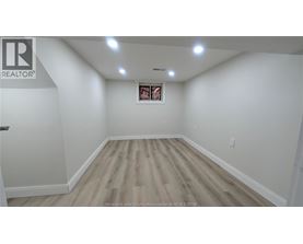 A room with wooden flooring and a picture frame on the wall.