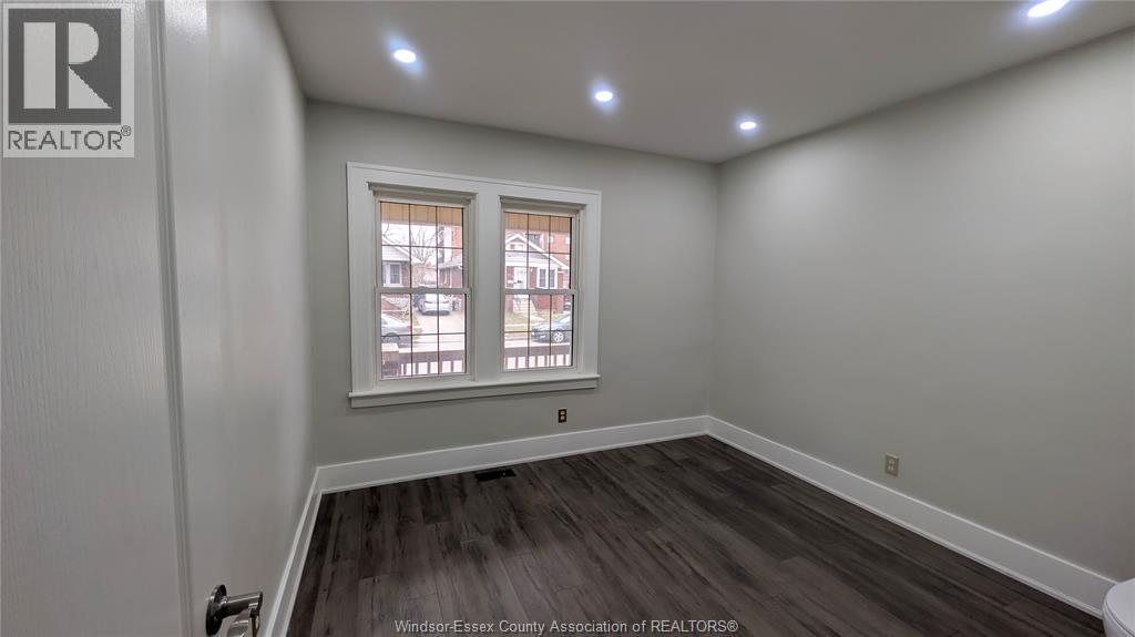 A room with a window and a wooden floor.