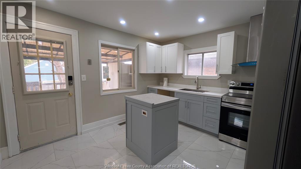 A kitchen with white cabinets and a central island.