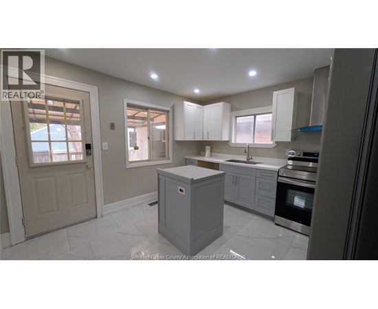 A kitchen with white cabinets and a central island.