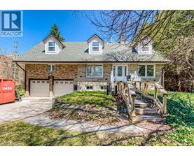 A house with a garage and a REALTOR sign in front.