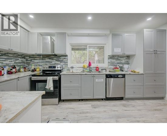 A kitchen with a white counter top and grey cabinets.