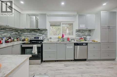 A kitchen with a white counter top and grey cabinets.