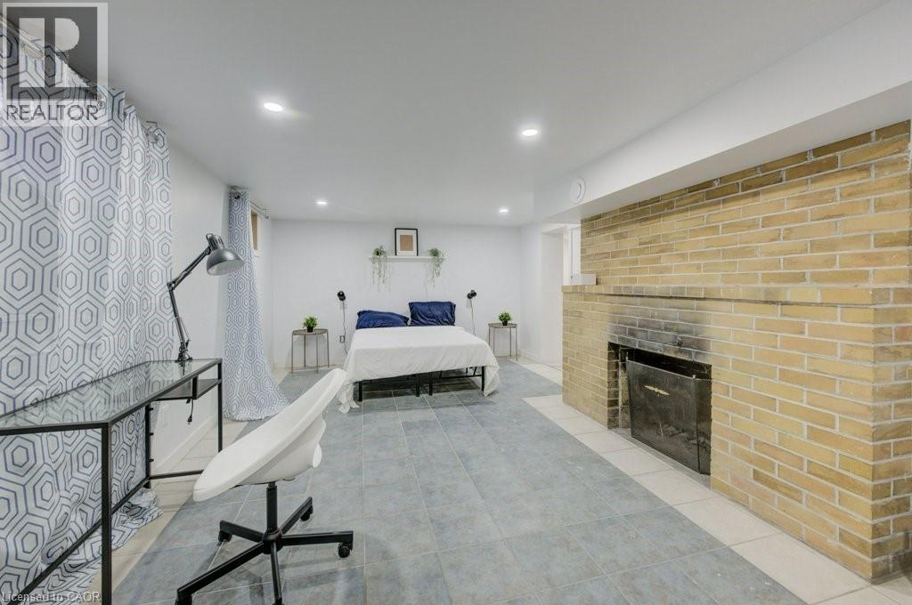 A modern bedroom with a brick fireplace and a bed with blue pillows.