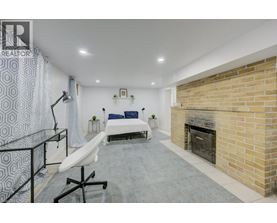 A modern bedroom with a brick fireplace and a bed with blue pillows.