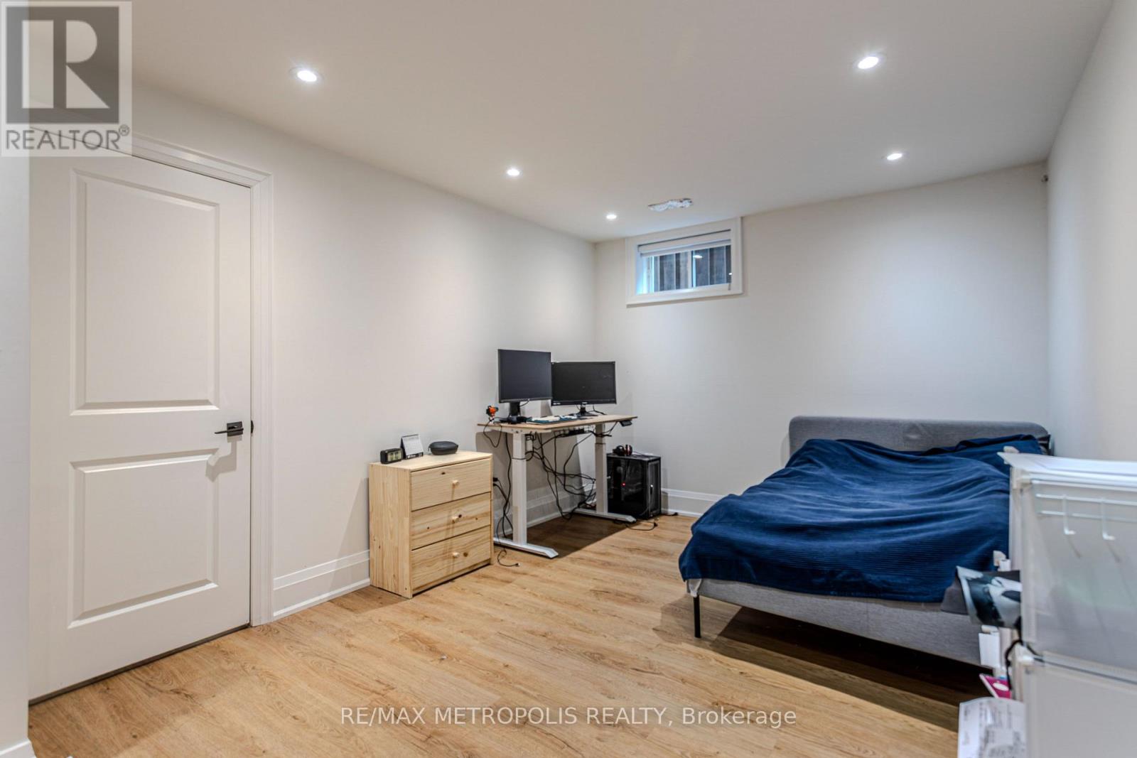 A bedroom with a bed, desk, and chair.