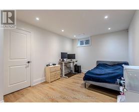 A bedroom with a bed, desk, and chair.