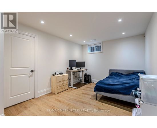 A bedroom with a bed, desk, and chair.