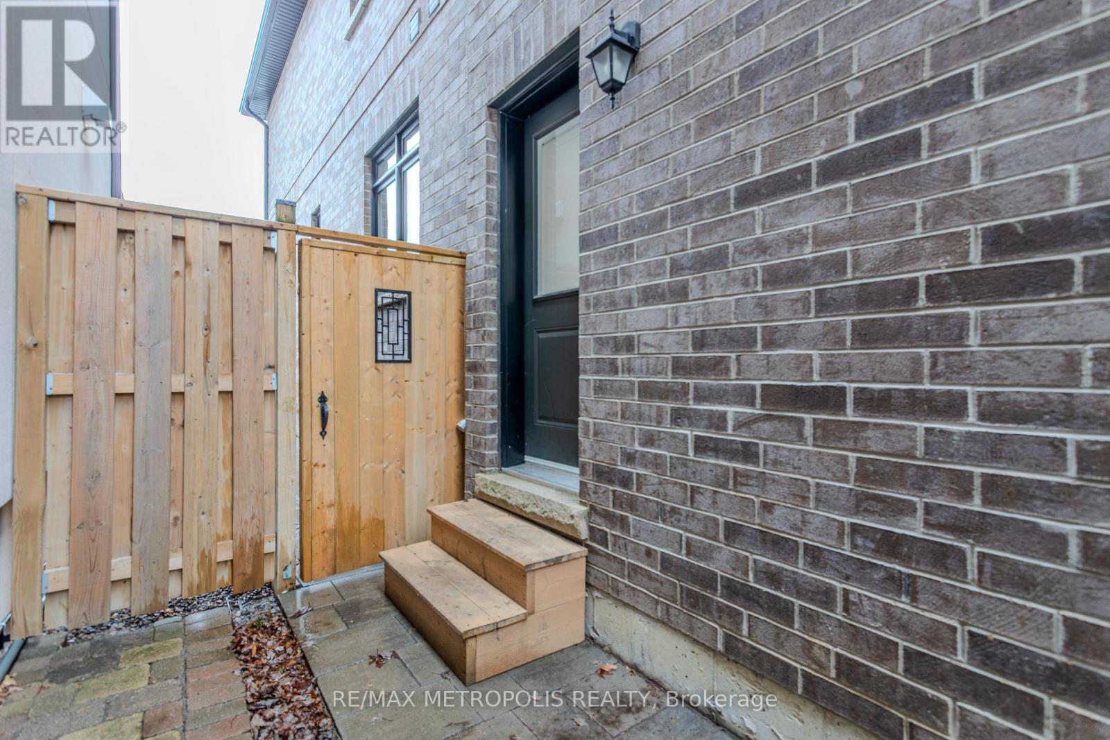 A wooden gate blocks the entrance to a brick building.