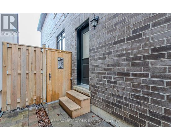 A wooden gate blocks the entrance to a brick building.