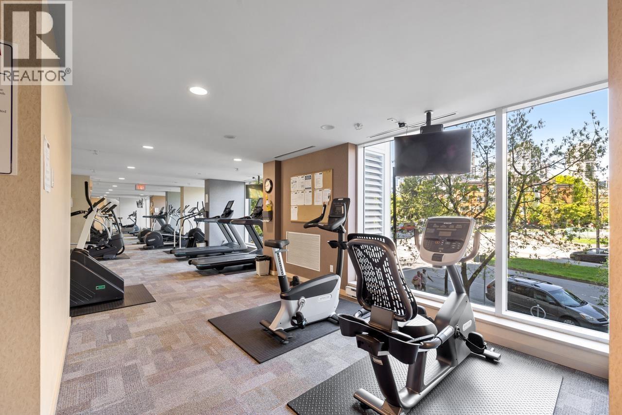 A gym with a row of treadmills and elliptical machines.