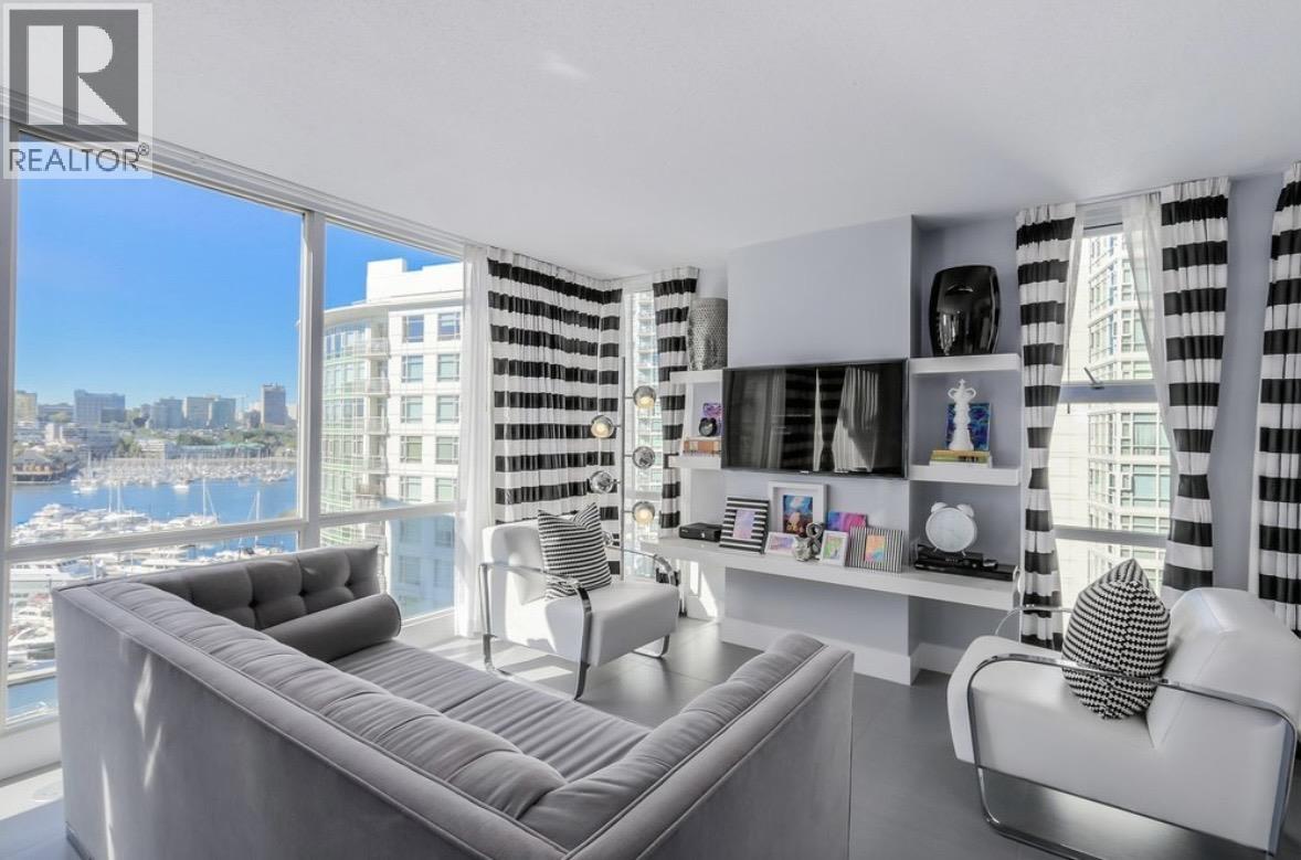 A living room with a grey sofa and a view of the city.