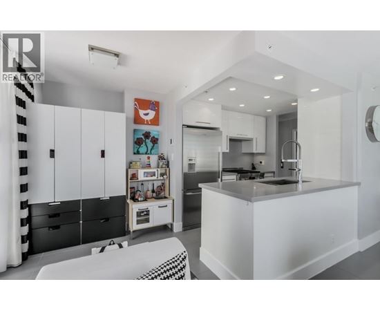 A modern kitchen with white cabinets and a black and white checkered bench.