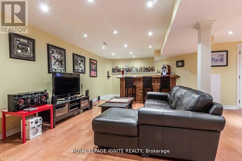 A living room with a black leather couch and a red table.