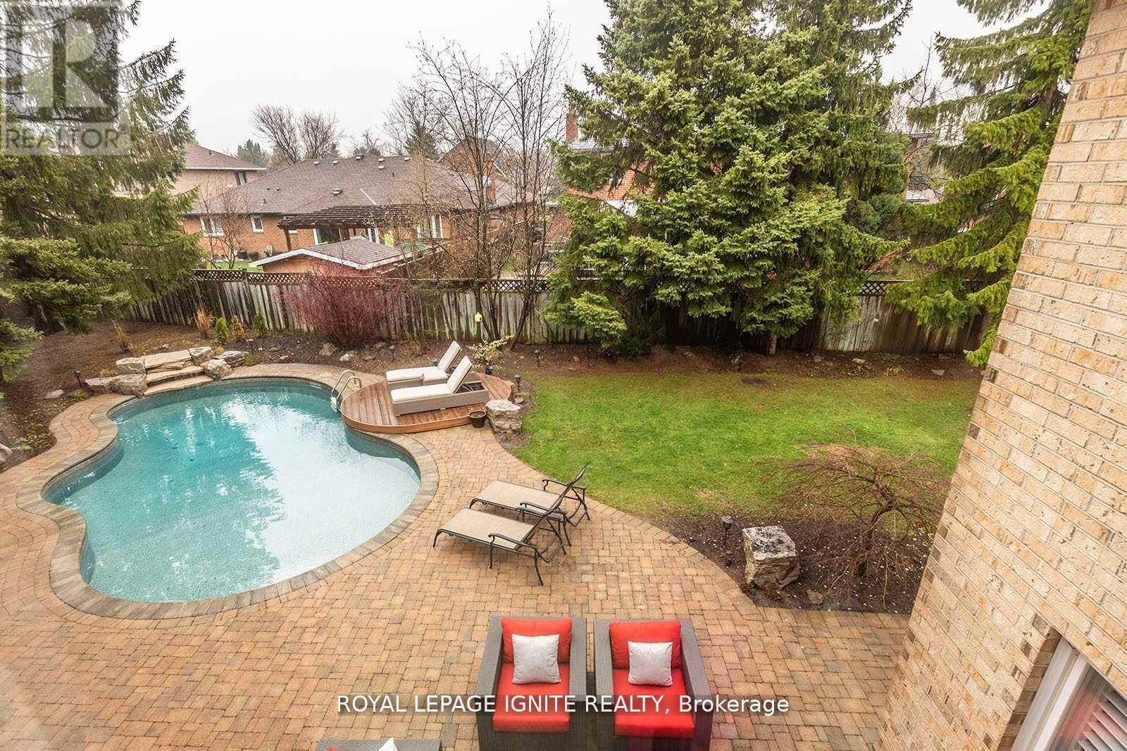 A backyard with a pool and patio furniture.