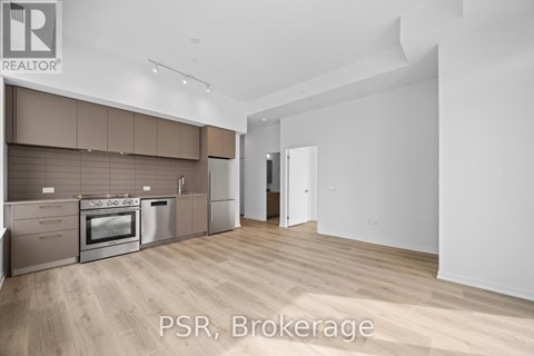 A modern kitchen with white cabinets and a view of the city.