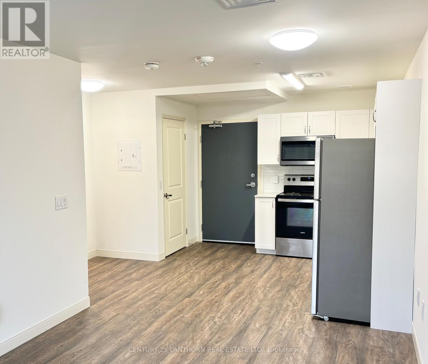 A kitchen area with a refrigerator, oven, and microwave.
