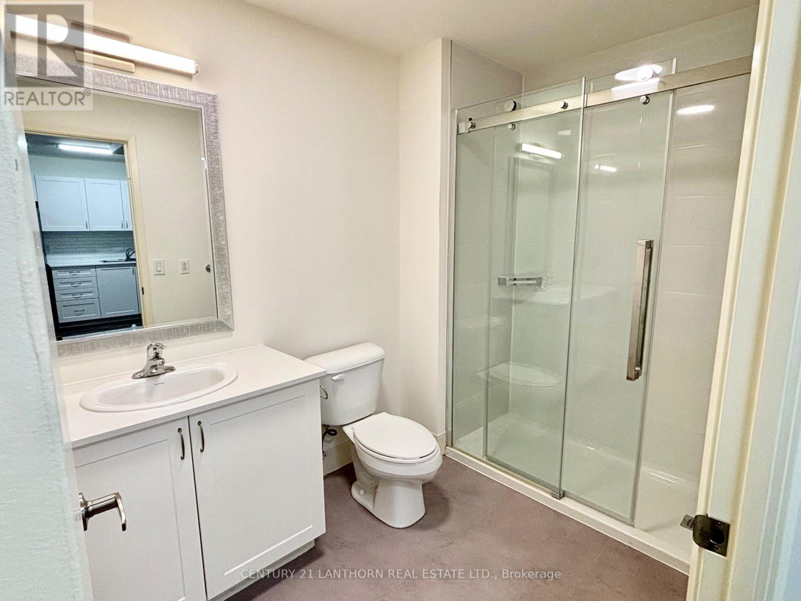 A white bathroom with a sink, toilet and shower.