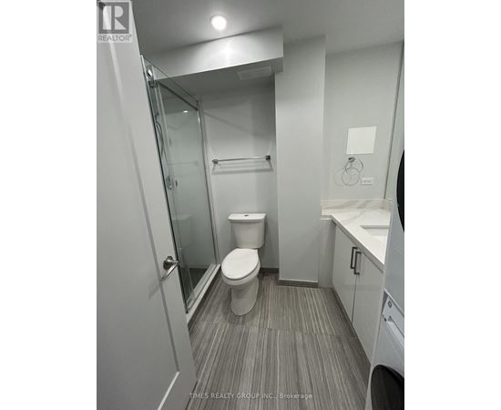 A bathroom with a toilet, sink, and mirror.