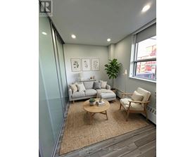 A living room with a grey couch, a wooden coffee table, and a green plant.