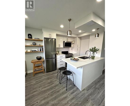 A kitchen with a white counter and a black chair.