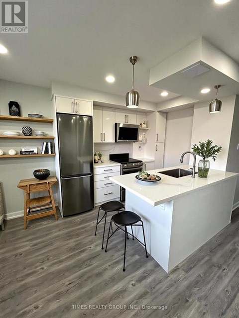 A kitchen with a white counter and a black chair.