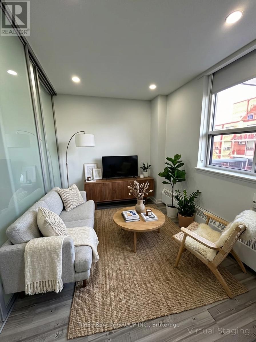 A living room with a grey couch, a wooden coffee table, and a white chair.