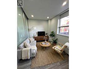 A living room with a grey couch, a wooden coffee table, and a white chair.