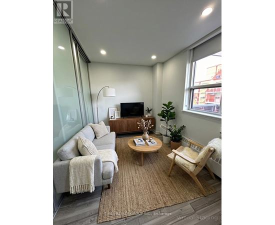 A living room with a grey couch, a wooden coffee table, and a white chair.