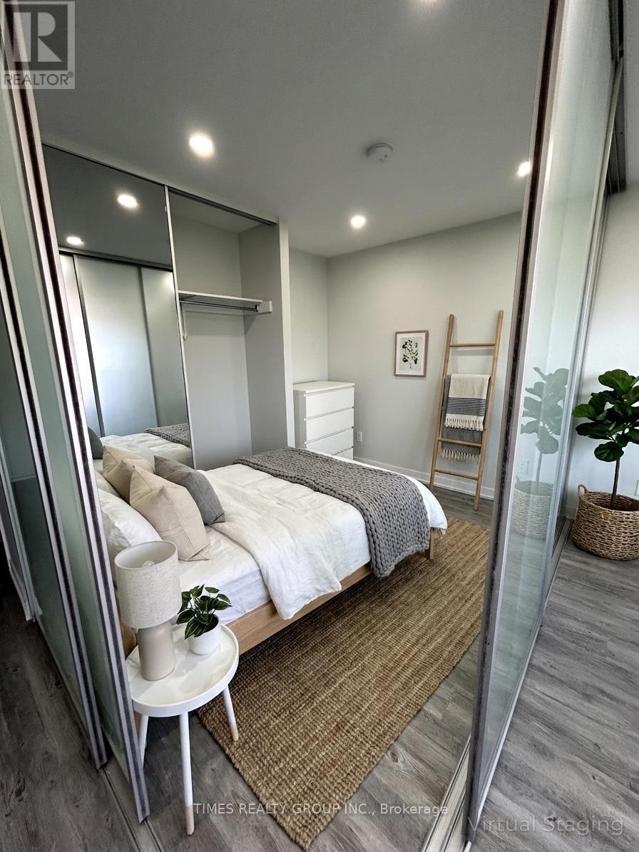 A bedroom with a bed, a chair, and a mirror.