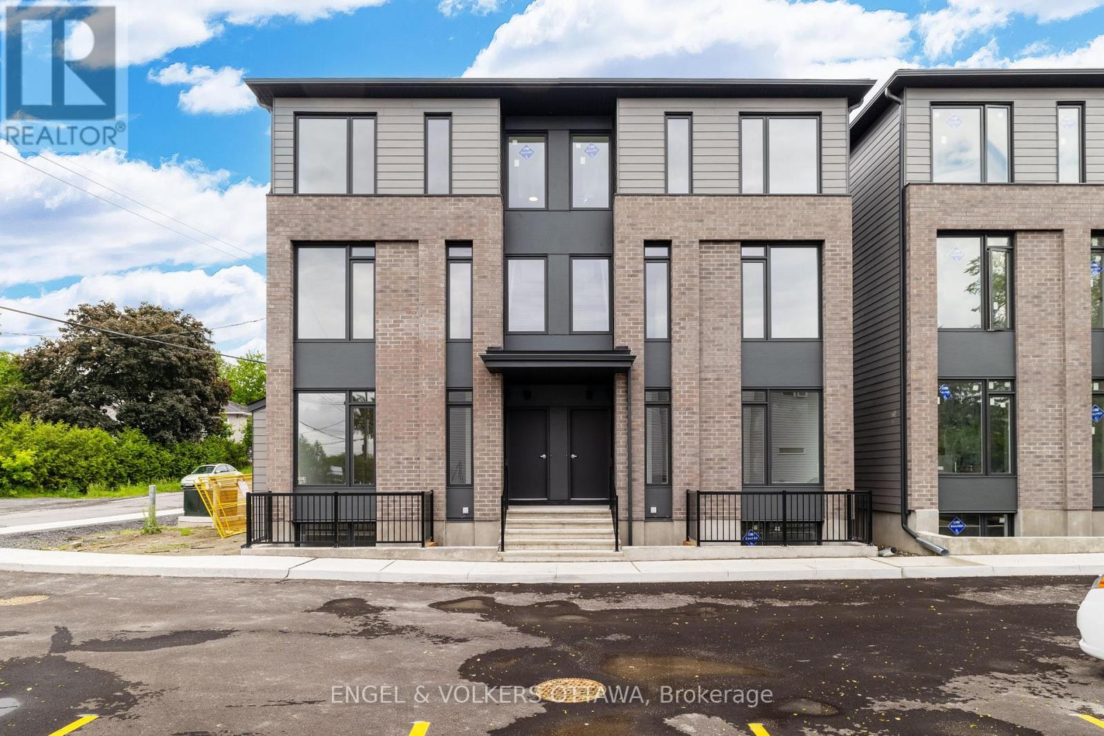 A modern apartment building with a black front door and windows.