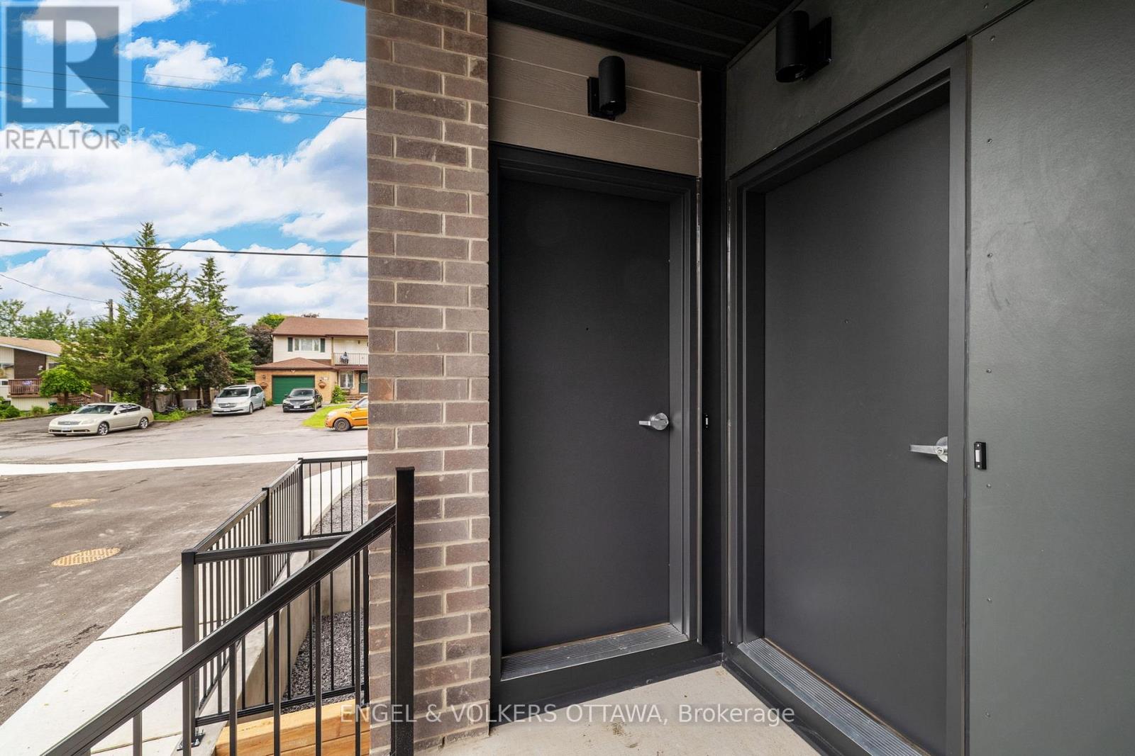 A realtor's sign is displayed on a building in the background of a photo showing a door entrance.